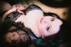 woman in black lace gown laying on back for a Boudoir Photograph