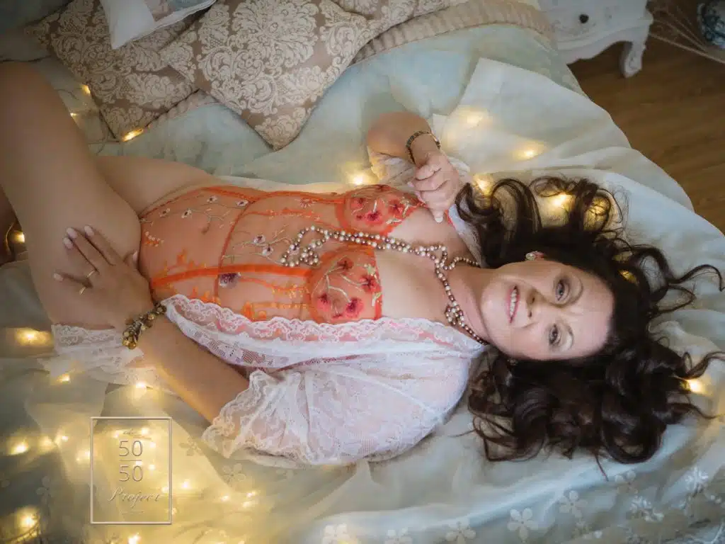 mature woman laying on bed for a boudoir photoshoot