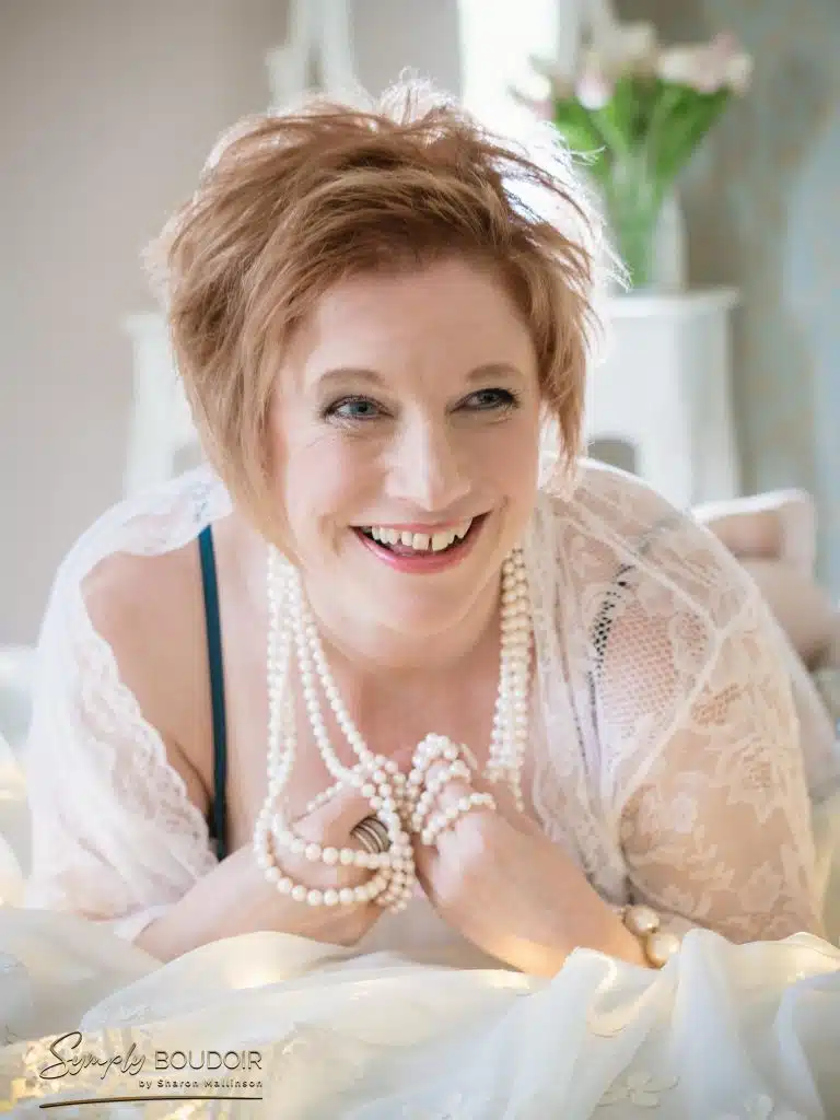 Boudoir photoshoot wearing white lace robe for the 50 over 50 project