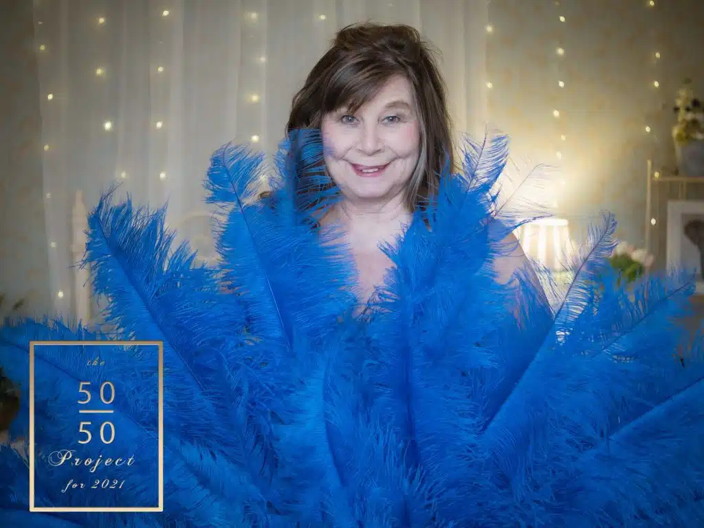mature woman with burlesque feathers for her 50 over 50 project shoot