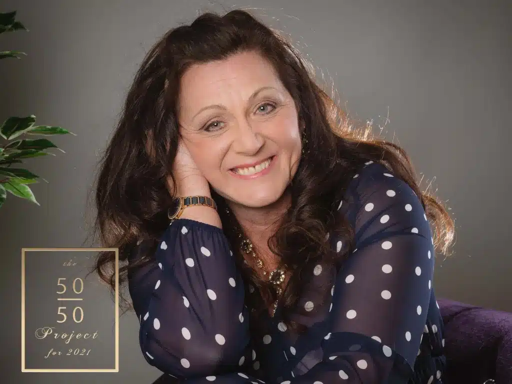 woman in blue polka dot dress having 50 over 50 boudoir photoshoot