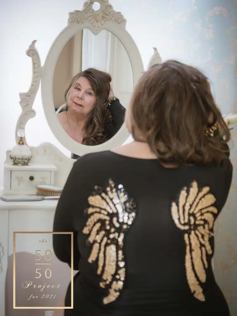 woman looking in mirror for 50 over 50 project