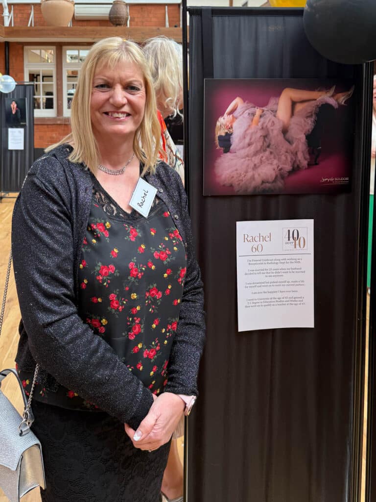 Symply Boudoir event attendee standing next to a photo display