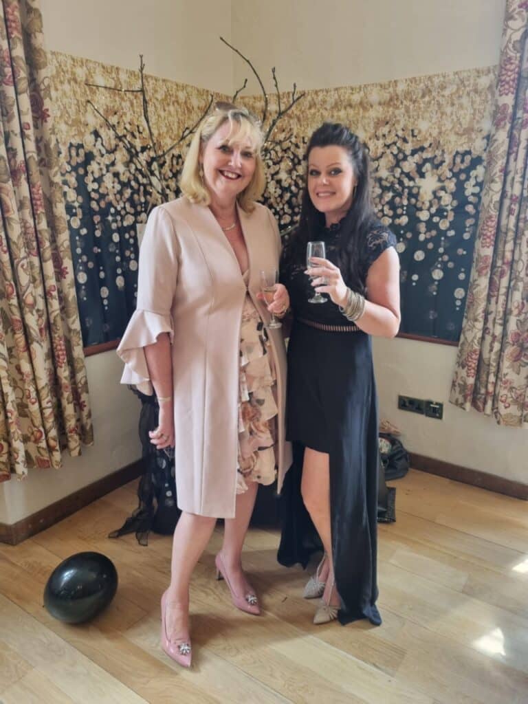 the two women running Symply boudoir posing for photos at 50/50 exhibition