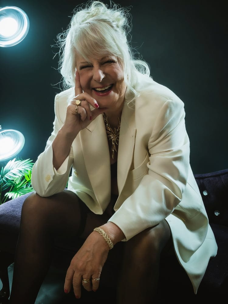 close up portrait of woman in her 70's wearing cream jacket for boudoir photoshoot